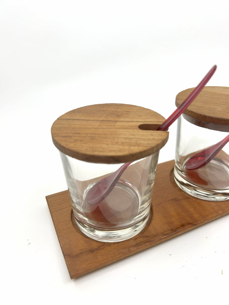 Mid Century Servierset aus Teak und Glas, Italien – Detailaufnahme mit Holzdeckel und rotem Kunststofflöffel im Glas.