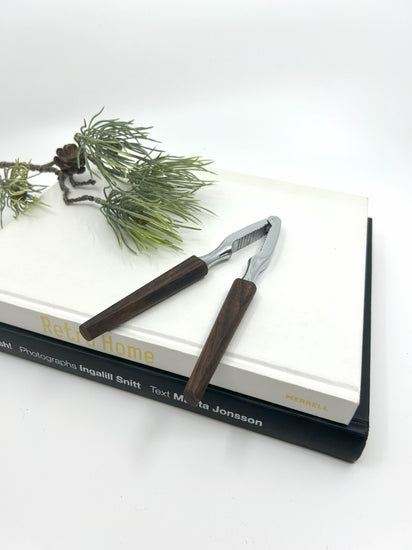 Vintage Teak Nussknacker aus Dänemark, 1950er Jahre, mit Metallzange und dunkelbraunen Holzgriffen im Mid Century Modern Design, stilvoll auf Büchern dekoriert.