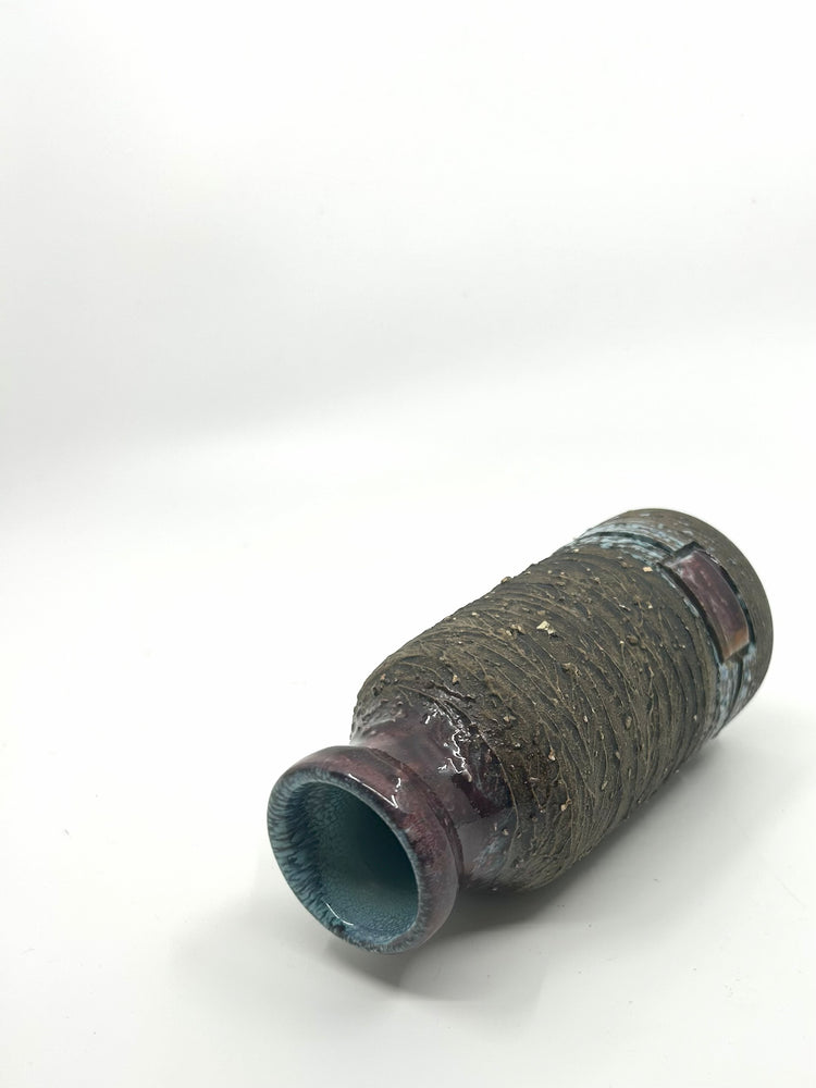 Liegende Ansicht der Tilgmans Brutalist Vase mit grober Struktur und dunkelrot glasiertem Hals.