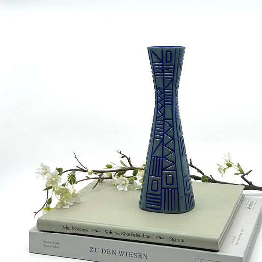 Upsala-Ekeby 'Labyrint' Vase von Hjördis Oldfors: Keramikvase mit geometrischen Reliefs und tiefblauem Innenbereich, inszeniert mit weißen Blütenzweigen auf Büchern – hochwertige schwedische Keramikkunst und Mid-Century Modern Stil