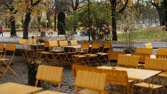 gelbe Holzstühlle und Tische in einem herbstlichen Park in Stockholm