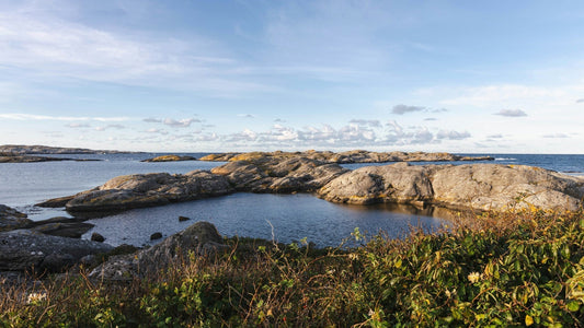 Idyllische Schärenlandschaft bei Stockholm: Klare, ruhige Gewässer zwischen glatten Felseninseln unter blauem Himmel – typisch schwedische Natur und skandinavische Küstenatmosphäre