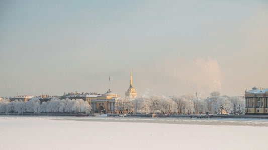 Winterliches Panorama von St. Petersburg mit Blick auf die Newa und die goldene Admiralitätskuppel – verschneite Stadtansicht im weichen Morgenlicht