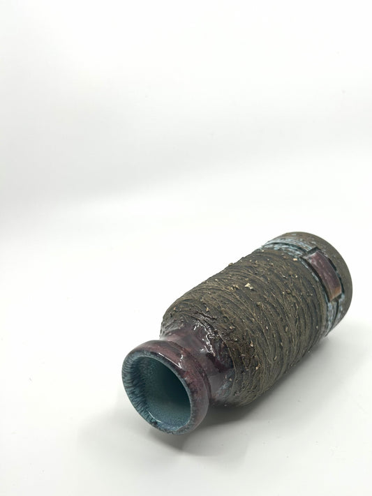Liegende Ansicht der Tilgmans Brutalist Vase mit grober Struktur und dunkelrot glasiertem Hals.