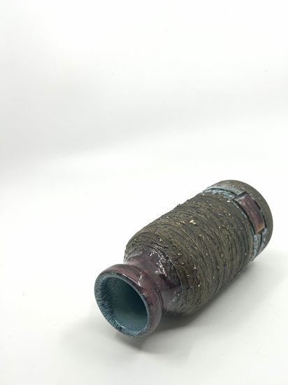 Liegende Ansicht der Tilgmans Brutalist Vase mit grober Struktur und dunkelrot glasiertem Hals.