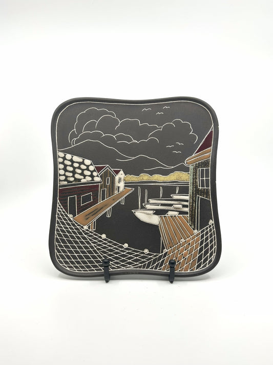 Rechteckige Keramik-Wandplatte von AWF aus den 60er Jahren mit maritimer Szene: Bootssteg, Fischerhäuser und Boote vor dramatisch bewölktem Himmel, Mid-Century Modern Design.