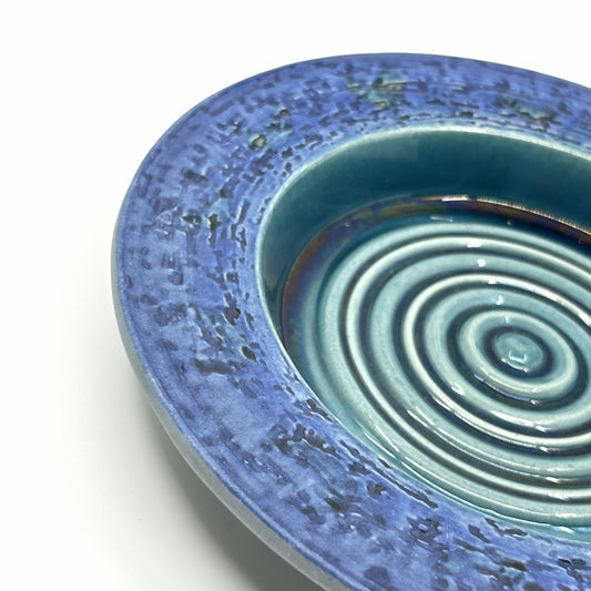 Detailansicht der Göran Andersson 'Anakonda' Schale: Blaue, strukturierte Glasur mit konzentrischen Kreisen und reliefartiger Oberfläche – schwedische Keramikkunst von Upsala-Ekeby