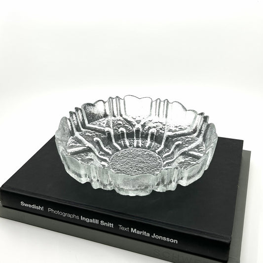 Tauno Wirkkala 'Ulpucca' Dekoschale aus Humppila, Finnland: Handgefertigte Glasschale mit organischen, Strukturen auf schwarzem Buch – finnische Glaskunst und skandinavisches Design