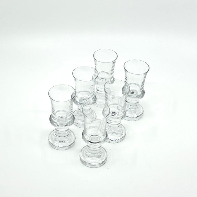 Set aus sechs Tavastia Digestifgläsern von Tapio Wirkkala für Iittala, Finnland, 1970er-Jahre. Klarglas im Stil der skandinavischen Moderne mit elegant geformtem Fuß und zeitlosem Design.